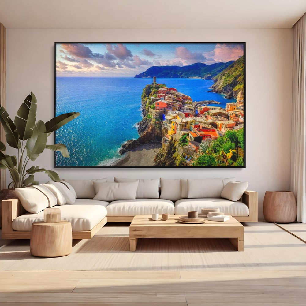 Tablou canvas cu peisaj costier italian cu sat colorat pe stanca, in rama de aluminiu negru, pe perete intr-un living